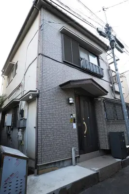 a brick building with a door and a balcony at Kimiko Jujo House - Local Art Stay 11 min Shinjuku in Tokyo