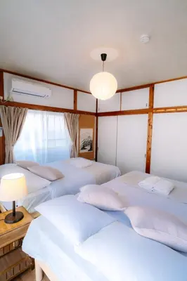 a bedroom with three beds and a window at Kimiko Jujo House - Local Art Stay 11 min Shinjuku in Tokyo