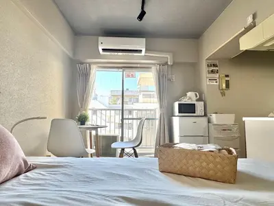 a bedroom with a bed and a kitchen with a balcony at ShinjukuCityStay 525 in Tokyo