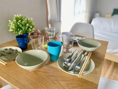 a wooden table with plates and utensils on it at ShinjukuCityStay 525 in Tokyo