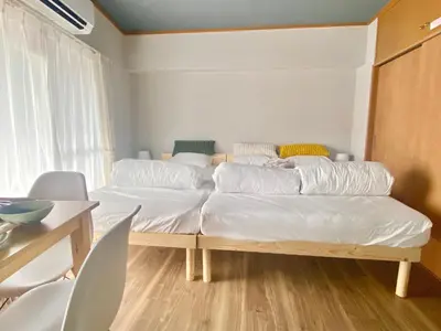two beds in a room with a table and chairs at ShinjukuCityStay 525 in Tokyo