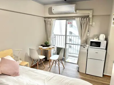 a room with a bed and a kitchen with a balcony at ShinjukuCityStay 525 in Tokyo