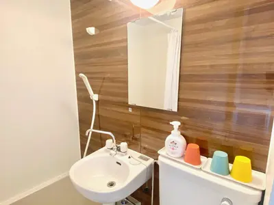 a bathroom with a sink and a toilet with a mirror at ShinjukuCityStay 525 in Tokyo