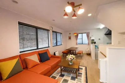 a living room with an orange couch and a table at Prime Shinjuku - 12min to Kabukicho - Quiet Park Area - Entire House - 3BD 6Beds - 70 sqm 750 sqft in Tokyo
