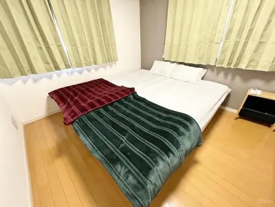 a bedroom with a bed with a green blanket on it at Prime Shinjuku - 12min to Kabukicho - Quiet Park Area - Entire House - 3BD 6Beds - 70 sqm 750 sqft in Tokyo