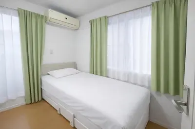 a white bed in a room with green curtains at Prime Shinjuku - 12min to Kabukicho - Quiet Park Area - Entire House - 3BD 6Beds - 70 sqm 750 sqft in Tokyo