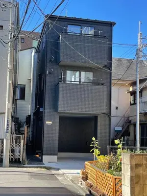 a black brick building with a garage at Newly built house with free parking, 3 minutes walk from Shinkoiwa Station in Tokyo