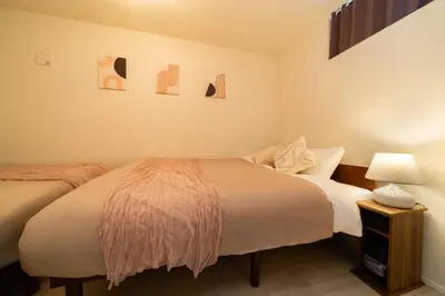 a bedroom with two beds and a table with a lamp at Tokyo Sky Hotel, \u6771\u4eac\u30b9\u30ab\u30a4\u30db\u30c6\u30eb \u65b0\u7bc9\u30f4\u30a3\u30e93\u968e\u5efa\u3066, \u30b9\u30ab\u30a4\u30c4\u30ea\u30fc\u30a8\u30ea\u30a2\u307e\u30676\u5206, \u99c5\u5f92\u6b694\u5206, \u6700\u592715\u540d\u69d8\u3054\u5229\u7528\u53ef\u80fd in Tokyo
