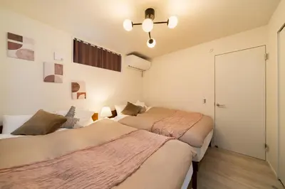a bedroom with two beds and a closet at Tokyo Sky Hotel, \u6771\u4eac\u30b9\u30ab\u30a4\u30db\u30c6\u30eb \u65b0\u7bc9\u30f4\u30a3\u30e93\u968e\u5efa\u3066, \u30b9\u30ab\u30a4\u30c4\u30ea\u30fc\u30a8\u30ea\u30a2\u307e\u30676\u5206, \u99c5\u5f92\u6b694\u5206, \u6700\u592715\u540d\u69d8\u3054\u5229\u7528\u53ef\u80fd in Tokyo