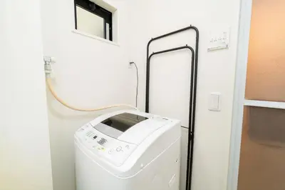 a washer and dryer in a small room at Tokyo Sky Hotel, \u6771\u4eac\u30b9\u30ab\u30a4\u30db\u30c6\u30eb \u65b0\u7bc9\u30f4\u30a3\u30e93\u968e\u5efa\u3066, \u30b9\u30ab\u30a4\u30c4\u30ea\u30fc\u30a8\u30ea\u30a2\u307e\u30676\u5206, \u99c5\u5f92\u6b694\u5206, \u6700\u592715\u540d\u69d8\u3054\u5229\u7528\u53ef\u80fd in Tokyo