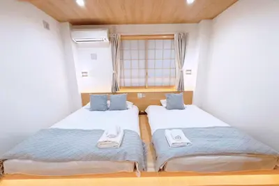 two twin beds in a room with a window at M101 5-minute walk from Minowa Station on the Hibiya Line, straight to Ueno, Akihabara, Ginza in Tokyo