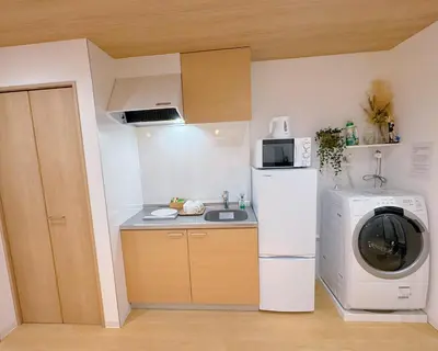 a small kitchen with a washing machine and a washer at M101 5-minute walk from Minowa Station on the Hibiya Line, straight to Ueno, Akihabara, Ginza in Tokyo