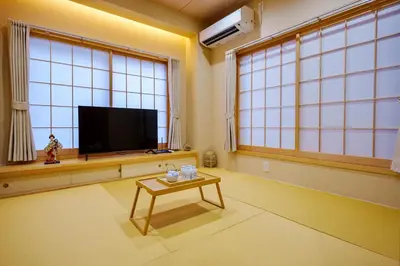 a living room with a flat screen tv and a table at M201 Hibiya Line, 5-minute walk to Minowa ! Straight line to Ueno, Akihabara ,and Roppongi! Family room for 5-6 people! in Tokyo