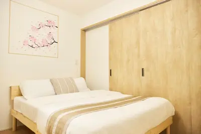 a bedroom with a bed and a wooden door at Edelweiss 301 in Tokyo