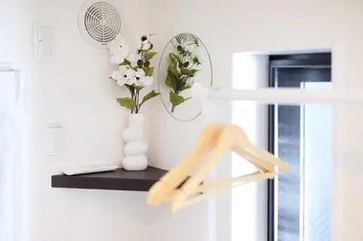 a shelf with a vase of flowers and a mirror at ohayo\u5c0f\u5c71\u53f0 in Tokyo