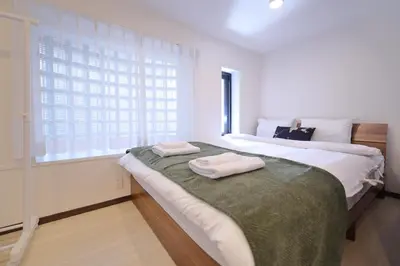a bedroom with a large bed with two towels on it at ohayo\u5c0f\u5c71\u53f0 in Tokyo
