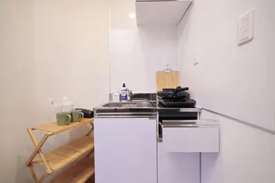 a kitchen with a sink and a white refrigerator at ohayo\u5c0f\u5c71\u53f0 in Tokyo