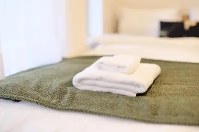 a pile of towels sitting on top of a bed at ohayo\u5c0f\u5c71\u53f0 in Tokyo