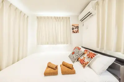 a bedroom with a white bed with two towels at Shinjuku Area Top-Tier Luxury, 4 min Walk to Station, Stay in a Traditional Japanese Beauty Ukiyo-e Art Villa, Shinjuku 13 min, Sleeps 8, Entire New 3BR House, 60sqm, Free Parking, Roppongi and Tsukiji direct access in Tokyo