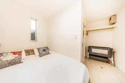 a white bedroom with a bed and a television at Shinjuku Area Top-Tier Luxury, 4 min Walk to Station, Stay in a Traditional Japanese Beauty Ukiyo-e Art Villa, Shinjuku 13 min, Sleeps 8, Entire New 3BR House, 60sqm, Free Parking, Roppongi and Tsukiji direct access in Tokyo