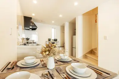 a dining room table with a vase of flowers on it at Shinjuku Area Top-Tier Luxury, 4 min Walk to Station, Stay in a Traditional Japanese Beauty Ukiyo-e Art Villa, Shinjuku 13 min, Sleeps 8, Entire New 3BR House, 60sqm, Free Parking, Roppongi and Tsukiji direct access in Tokyo
