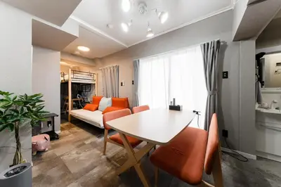 a living room with a table and a couch at SHINBASHI Station A major hub station ideal for Tokyo sightseeing Numerous restaurants and eateries surround the station Enjoy your stay on the top floor of the building without worrying about noise Elevator available in Tokyo