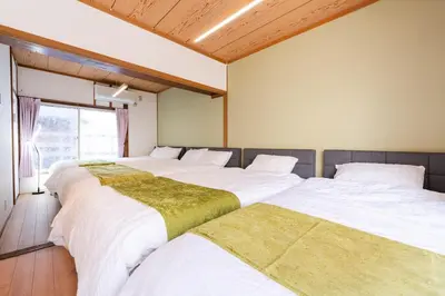 a row of three beds in a room at Asakusa, Ueno, Akihabara MAX 6 guests Entire building rental Ideal base for Tokyo sightseeing Manga, games, large-screen TV in Tokyo