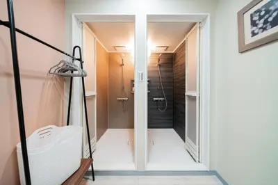 a bathroom with a walk in shower next to a door at B1 Shibuya, 4 bedrooms and 1 living room 2 bathrooms 2 toilets, 7 mins to ST Max 8P \u6e0b\u8c37\u5168\u65b0\u88c5\u4fee \u56db\u5ba4\u4e00\u5385 \u4ea4\u901a\u4e2d\u5fc3 \u8f66\u7ad97\u5206\u949f \u6700\u59278\u4eba \u76f4\u8fbe\u65b0\u5bbf \u6d89\u8c37 \u8868\u53c2\u9053 \u54c1\u5ddd \u6c60\u888b \u4e0a\u91ce \u4ee3\u4ee3\u6728 \u94f6\u5ea7 \u539f\u5bbf in Tokyo