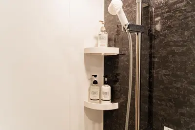 a shower with two bottles on a shelf in a bathroom at C1 Shibuya, 2 bedrooms and 1 living room 2 bathrooms 2 toilets, 7 mins to ST Max 6P \u6e0b\u8c37\u5168\u65b0\u88c5\u4fee \u4e24\u5ba4\u4e00\u5385 \u4ea4\u901a\u4e2d\u5fc3 \u8f66\u7ad97\u5206\u949f \u6700\u59276\u4eba \u76f4\u8fbe\u65b0\u5bbf \u6d89\u8c37 \u8868\u53c2\u9053 \u54c1\u5ddd \u6c60\u888b \u4e0a\u91ce \u4ee3\u4ee3\u6728 \u94f6\u5ea7 \u539f\u5bbf in Tokyo