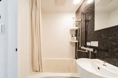 a white bathroom with a shower and a sink at C1 Shibuya, 2 bedrooms and 1 living room 2 bathrooms 2 toilets, 7 mins to ST Max 6P \u6e0b\u8c37\u5168\u65b0\u88c5\u4fee \u4e24\u5ba4\u4e00\u5385 \u4ea4\u901a\u4e2d\u5fc3 \u8f66\u7ad97\u5206\u949f \u6700\u59276\u4eba \u76f4\u8fbe\u65b0\u5bbf \u6d89\u8c37 \u8868\u53c2\u9053 \u54c1\u5ddd \u6c60\u888b \u4e0a\u91ce \u4ee3\u4ee3\u6728 \u94f6\u5ea7 \u539f\u5bbf in Tokyo