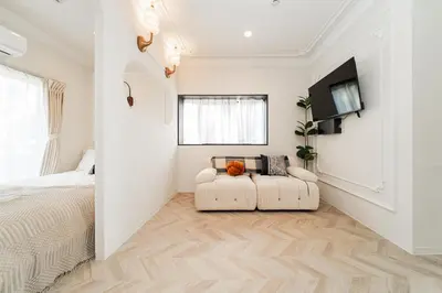 a white bedroom with a bed and a couch at C1 Shibuya, 2 bedrooms and 1 living room 2 bathrooms 2 toilets, 7 mins to ST Max 6P \u6e0b\u8c37\u5168\u65b0\u88c5\u4fee \u4e24\u5ba4\u4e00\u5385 \u4ea4\u901a\u4e2d\u5fc3 \u8f66\u7ad97\u5206\u949f \u6700\u59276\u4eba \u76f4\u8fbe\u65b0\u5bbf \u6d89\u8c37 \u8868\u53c2\u9053 \u54c1\u5ddd \u6c60\u888b \u4e0a\u91ce \u4ee3\u4ee3\u6728 \u94f6\u5ea7 \u539f\u5bbf in Tokyo