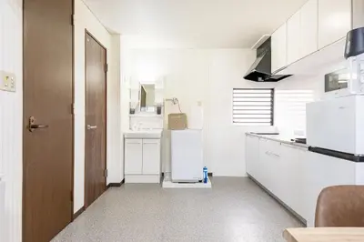 a kitchen with white appliances and a refrigerator at \u6d45\u8349\u30de\u30a4\u30db\u30c6\u30eb Asakusa My apartment Hotel in Tokyo
