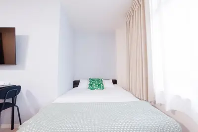 a bedroom with a white bed with a green pillow at Astra Nakano hostel max6 people NN0494 in Tokyo