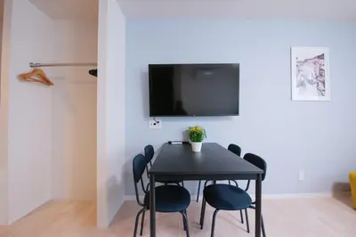 a dining room table with chairs and a tv on a wall at Astra Nakano hostel max6 people NN0494 in Tokyo