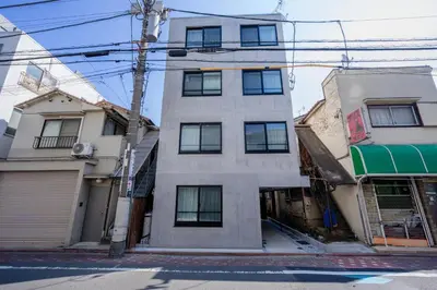 a tall white building on a city street at Crecer Apartment Hotel kamata in Tokyo