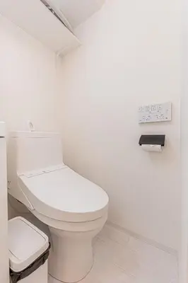 a bathroom with a toilet and a clock on the wall at Crecer Apartment Hotel kamata in Tokyo