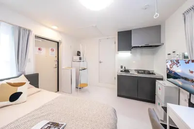a room with a bed and a kitchen in it at Crecer Apartment Hotel kamata in Tokyo