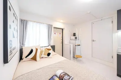 a white bedroom with a bed with pillows at Crecer Apartment Hotel kamata in Tokyo