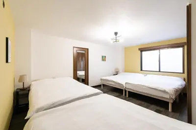 a bedroom with two beds and a window at Kotori Ayase in Tokyo