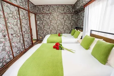two beds in a room with green and red flowers at 201Room 1 Stop from Ikebukuro Entire 33m on 2st Floor 2 Bedrooms for up to 6 Guests 3Minute Walk to Don Quijote in Tokyo