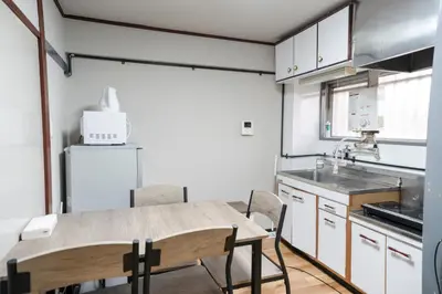 a kitchen with a table and chairs and a refrigerator at 201Room 1 Stop from Ikebukuro Entire 33m on 2st Floor 2 Bedrooms for up to 6 Guests 3Minute Walk to Don Quijote in Tokyo