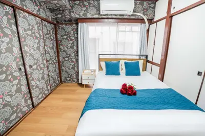 a bedroom with a bed with blue and red pillows at 201Room 1 Stop from Ikebukuro Entire 33m on 2st Floor 2 Bedrooms for up to 6 Guests 3Minute Walk to Don Quijote in Tokyo