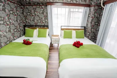 two beds in a room with green and red flowers at 201Room 1 Stop from Ikebukuro Entire 33m on 2st Floor 2 Bedrooms for up to 6 Guests 3Minute Walk to Don Quijote in Tokyo