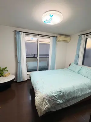 a bedroom with a bed and a large window at sakura\u306e\u5bb6 in Tokyo