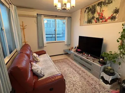 a living room with a leather couch and a flat screen tv at sakura\u306e\u5bb6 in Tokyo