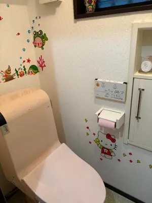 a bathroom with a toilet with stickers on the wall at sakura\u306e\u5bb6 in Tokyo