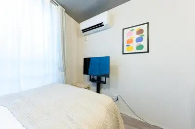 a bedroom with a bed and a flat screen tv at Tokyo 3min Gotanno Station couples friends 20sqm in Tokyo