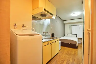a small kitchen with a sink and a bed at \u65b0\u5bbf\u5e02\u4e2d\u5fc3\u6771\u65b0\u5bbf\u7ad9\u5f92\u6b653\u5206\u937e\u6b4c\u821e\u4f0e\u753a\u7d27\u90bb\u4f0a\u52bf\u4e39\u767e\u8d27#12 in Tokyo