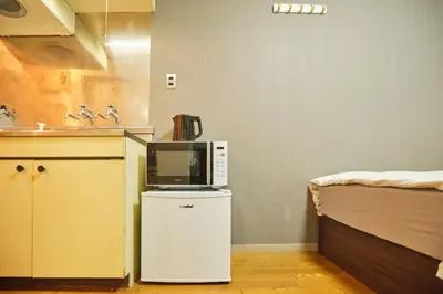 a microwave sitting on top of a refrigerator in a kitchen at \u65b0\u5bbf\u5e02\u4e2d\u5fc3\u6771\u65b0\u5bbf\u7ad9\u5f92\u6b653\u5206\u937e\u6b4c\u821e\u4f0e\u753a\u7d27\u90bb\u4f0a\u52bf\u4e39\u767e\u8d27#12 in Tokyo