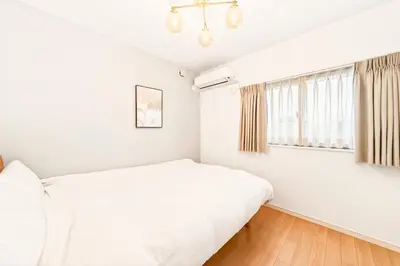 a white bedroom with a bed and a window at MaiMai Yahiro in Tokyo